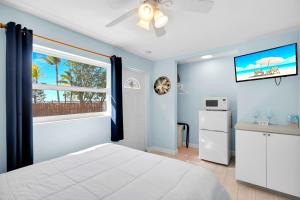 a bedroom with a white bed and a window at Sunset Cove Beach Resort in Key Largo