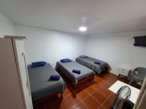a room with two beds and a chair in it at Hostal La Reserva - Pisco in Pisco +39 photos
