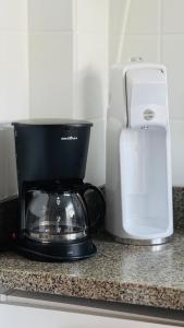 a coffee maker and a blender on a counter at Apê com vista para o mar e clima animado in Vitória