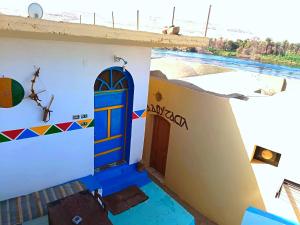 a house with a blue door on the side of it at Shellaly Ca Nubian Heritage House in Jazīrat Salūjah