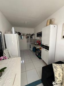 a small kitchen with a refrigerator and a table at Conteiner House in Pipa