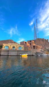 a yellow boat in the water in front of a building at Shellaly Ca Nubian Heritage House in Jazīrat Salūjah +14 photos