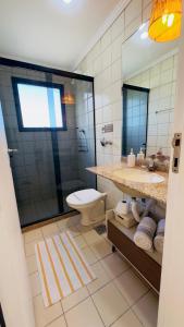 a bathroom with a toilet and a sink and a mirror at Apê com vista para o mar e clima animado in Vitória +38 photos