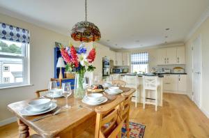 a kitchen and dining room with a wooden table and chairs at 5 Bed in Amroth oc-pw9067 in Amroth