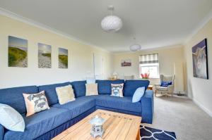 a blue couch in a living room with a table at 5 Bed in Amroth oc-pw9067 in Amroth