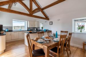 a kitchen and dining room with a wooden table and chairs at 3 Bed in Corwen oc-fl009 in Derwen