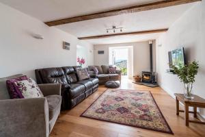 a living room with a leather couch and a rug at 3 Bed in Corwen oc-fl009 in Derwen