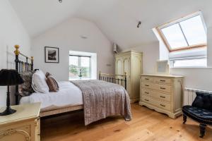 a bedroom with a bed and a dresser and a window at 3 Bed in Corwen oc-fl009 in Derwen