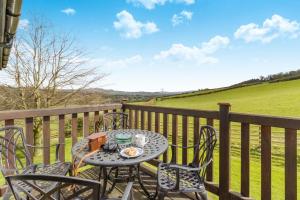 a table and chairs on a balcony with a view of a field at 2 Bed in Caersws oc-waa322 in Trefeglwys