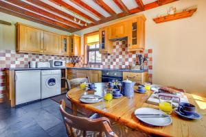 a kitchen with a wooden table with plates on it at 3 Bed in Caernarfon oc-wag443 in Llanwnda