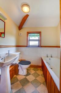 a bathroom with two sinks and a toilet and a tub at 3 Bed in Caernarfon oc-wag443 in Llanwnda