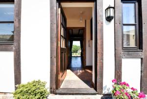 an open door of a white building with flowers at 1 Bed in Welshpool oc-75714 in Meifod