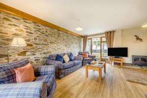 a living room with couches and a stone wall at 4 Bed in Builth Wells oc-39473 in Builth Wells