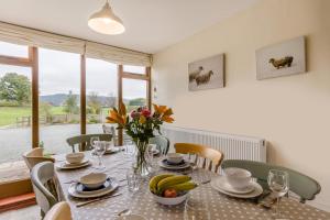 a dining room table with a vase of flowers on it at 4 Bed in Builth Wells oc-39473 in Builth Wells