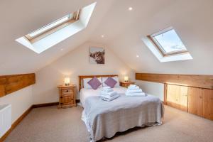 a bedroom with a bed with white sheets and skylights at 7 Bed in Caerwys oc-58357 in Caerwys