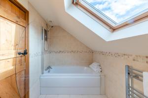 a bathroom with a bath tub and a skylight at 7 Bed in Caerwys oc-58357 in Caerwys +29 photos