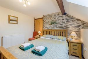 a bedroom with a large bed and a stone wall at 4 Bed in Builth Wells oc-39461 in Builth Wells