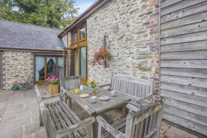a wooden table and two benches on a patio at 4 Bed in Builth Wells oc-39461 in Builth Wells