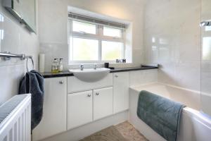 a bathroom with a tub and a sink and a bath tub at 4 Bed in Abersoch oc-dolwar in Abersoch +21 photos