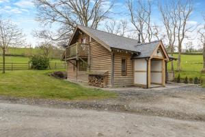 a small wooden cabin with a porch and a balcony at 2 Bed in Caersws oc-waa345 in Trefeglwys