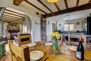 a dining room with a table with a bottle of wine at 2 Bed in Welshpool oc-75703 in Meifod