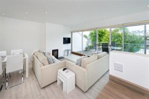 a living room with white furniture and large windows at 2 Bed in Pwllheli oc-45caed in Abersoch