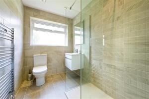 a bathroom with a toilet and a glass shower at 2 Bed in Pwllheli oc-45caed in Abersoch +7 photos