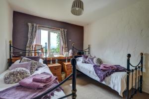 a bedroom with two beds and a window at 3 Bed in Llanfairpwllgwyngyll oc-wai194 in Dwyran
