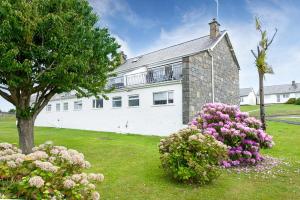 a large white house with flowers in front of it at 2 Bed in Pwllheli oc-45caed in Abersoch