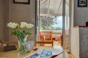 a vase of flowers on a table in a room at 3 Bed in Llanfairpwllgwyngyll oc-wai194 in Dwyran