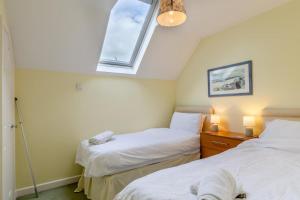 a bedroom with two beds and a window at 2 Bed in Charmouth oc-wy395 in Charmouth