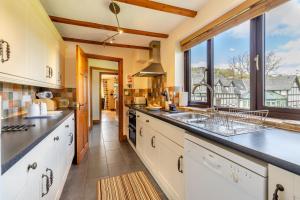 a kitchen with white cabinets and a large window at 4 Bed in Caersws oc-waa321 in Trefeglwys