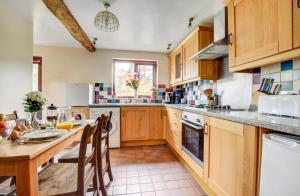 a kitchen with wooden cabinets and a table with chairs at 2 Bed in Brecon oc-37318 in Pentre-bâch +11 photos
