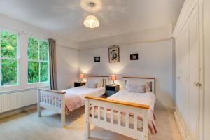 two beds in a bedroom with two windows at 6 Bed in Dolgellau oc-wah675 in Arthog