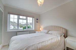 a white bedroom with a bed and a window at 2 Bed in Swanage oc-wy344 in Swanage