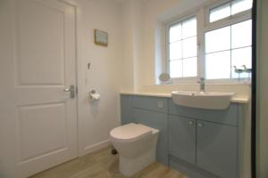 a bathroom with a toilet and a sink and a window at 2 Bed in Swanage oc-wy344 in Swanage +7 photos