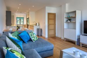 a living room with a blue couch and a kitchen at 3 Bed in Abersoch oc-9penyb in Abersoch