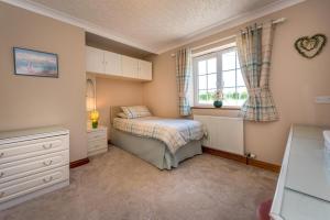 a small bedroom with a bed and a window at 5 Bed in Bryncroes oc-llecyn in Pwllheli