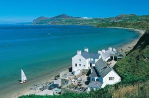 a large white house on a beach with a sailboat at 4 Bed in Morfa Nefyn oc-bow10 in Morfa Nefyn