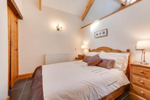 a bedroom with a large white bed and a dresser at 1 Bed in Gower oc-hh408 in Llanmadoc