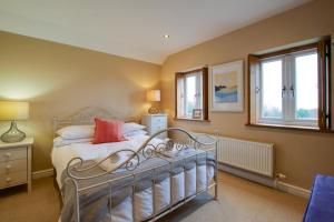 a bedroom with a bed and two windows at 4 Bed in Gower oc-hh701 in Port-Eynon