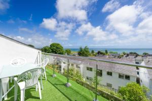 a balcony with a white table and chairs and the ocean at 3 Bed in Pwllheli oc-16glyn in Llanbedrog