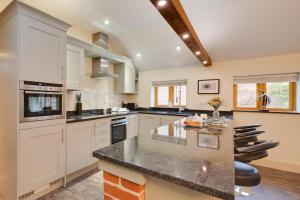 a kitchen with white cabinets and a black counter top at 1 Bed in Woodbridge oc-stabu in Ufford