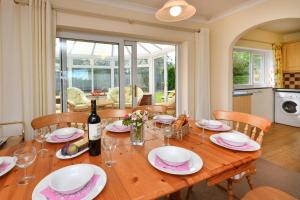a wooden table with chairs and a bottle of wine at 4 Bed in Pwllheli oc-morgra in Abersoch