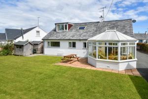 a white house with a conservatory in a yard at 4 Bed in Pwllheli oc-morgra in Abersoch
