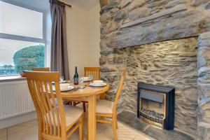 a dining room with a table and a fireplace at 2 Bed in Barmouth oc-wah698 in Talybont