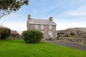an old stone house with a green lawn at 2 Bed in Barmouth oc-wah698 in Talybont