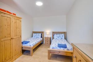 two twin beds in a room with a cabinet at 2 Bed in Gower oc-hh486 in Penclawdd