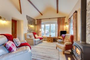 a living room with a wood stove and chairs at 3 Bed in Benllech oc-24195 in Benllech