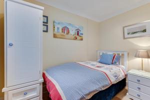 a small bedroom with a bed and a dresser at 3 Bed in Benllech oc-24195 in Benllech
